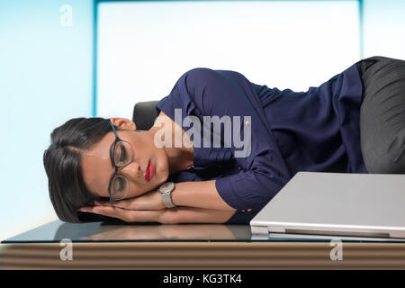 Businesswoman sleeping at desk in office Stock Photo