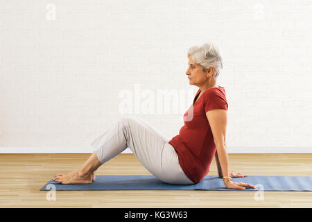 Senior woman doing exercise on mat Stock Photo