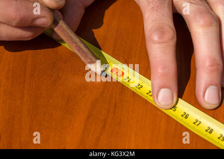 The carpenter measures the distance using a measure and marks with a ...