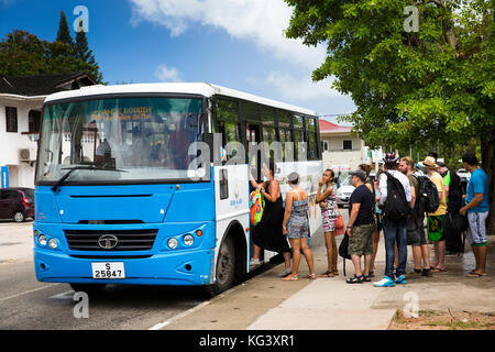 The Seychelles, Praslin, Grand Anse, passengers boarding local bus to Anse Boudin via Vallee de Mai Stock Photo