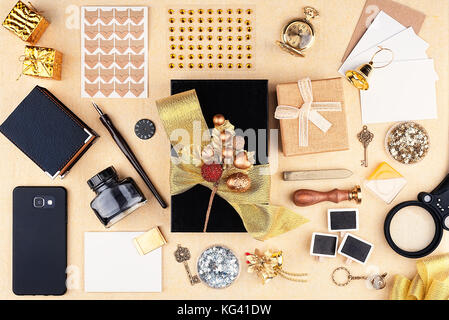 Gift wrap in the workplace. Top view. Black box with a gold bow and big group of tool Stock Photo