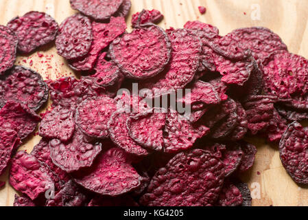 purple baked beet chips closeup on wooden background Stock Photo