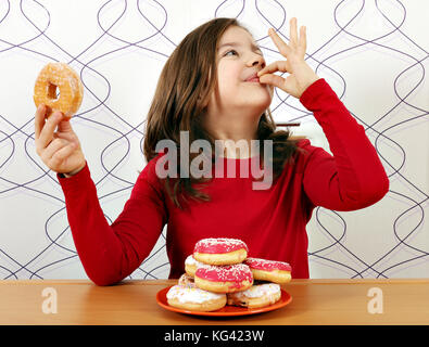 little girl enjoy in sweet donuts Stock Photo