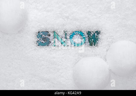 The word SNOW made from wooded letterpress letters on a snow background Stock Photo