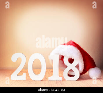 santa fur cap on a rustic wooden background with figures 2018 Stock Photo