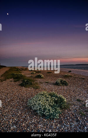 Beach scene at sunset on Hayling Island in Hampshire with the moon Stock Photo