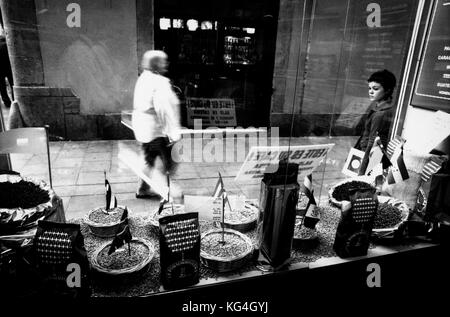 A girl looks at the coffee beans that are exhibited in the window of the Portorriqueña shop that is in Xucla street of Barcelona, Spain. Date: 05/2003. Photo: Xabier Mikel Laburu. Funded in 1902 by a puertorican woman called Graciales who married a man from Barcelona. The shop, specialized in coffee, changed to the current location in 1920. When Graciales retired, a worker called Eloy Alvarez would take over the business. And later on, his son Jordi Alvarez, would do the same. In 2006, after the unexpected death of Jordi, his widow, Carme Rigata, takes the reins of the shop. Despite the busine Stock Photo