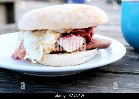 A tasty, mouth watering, breakfast bap made up of Sausage, bacon and egg bought from an outdoor café in Bristol, England, UK Stock Photo