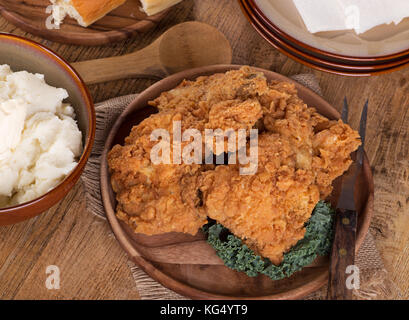 Fried chicken on a platter with mashed potatoes and rolls Stock Photo