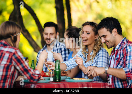 Group of happy people eating food outdoors Stock Photo