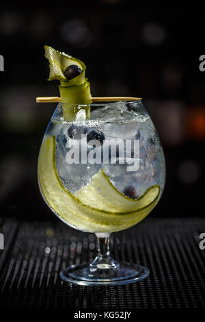 Gin tonic cocktail with cucumber, black currant and ice Stock Photo