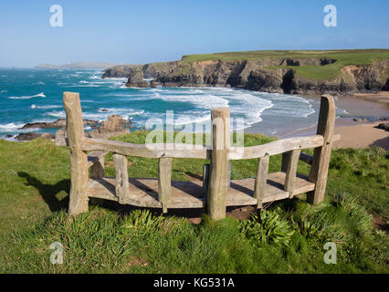 Robust wooden seat on the cliffs overlooking Porthcothan Bay on the north Cornish coast near Newquay UK Stock Photo