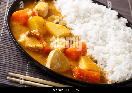 Japanese curry rice with meat, carrot and potato close-up on a plate on a table. Horizontal Stock Photo