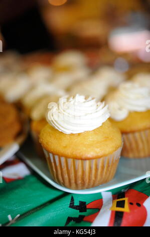 Close-up of frosted, decorated cupcakes, plated on a table at a community or family celebration. Stock Photo