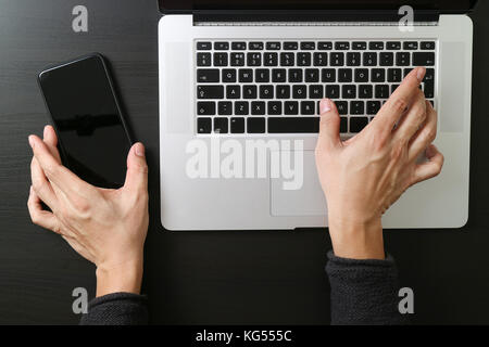 cyber security internet and networking concept.Businessman hand working mobile phone on laptop computer background Stock Photo