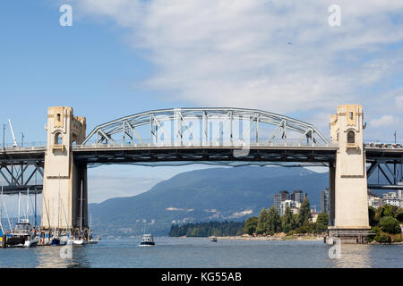 Boat ferries and yachts in False Creek Harbor with Burrard Bridge and Vancouver Yaletown skyline in the background. Stock Photo