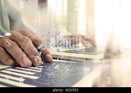 Hands of businessman using mobile phone in modern office with laptop and digital tablet computer in team meeting with VR icon diagram Stock Photo