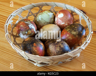 Abstract random color easter eggs in small wooden basket Stock Photo