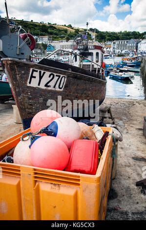 Fishing boat and floats on the harbour in Mevagissey, Cornwall Stock Photo
