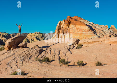 Woman looking at the spectacular redrock sandstone formations in the Valley of fire state park, Nevada, USA Stock Photo