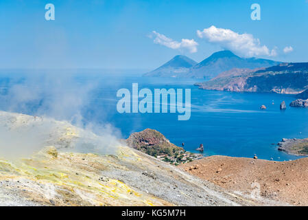 Volcano, Messina district, Sicily, Italy, Europe. Sulfur fumaroles on the crater rim of Vulcano. In the background the islands of Lipari and Salina Stock Photo