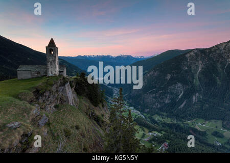 Ancient church at sunrise, San Romerio Alp, Brusio, Canton of Graubünden, Poschiavo valley, Switzerland Stock Photo
