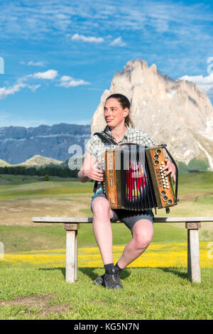 Alpe di Siusi / Seiser Alm, Dolomites, South Tyrol, Italy. Young woman playing with the accordion at the Alpe di Siusi Stock Photo