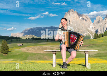 Alpe di Siusi / Seiser Alm, Dolomites, South Tyrol, Italy. Young woman playing with the accordion at the Alpe di Siusi Stock Photo