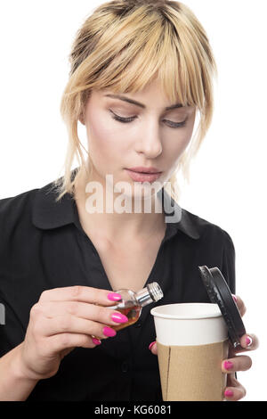 blonde haired business woman putting alcohol into her take away cup Stock Photo