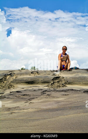 Caucasian woman reads a book in the beautiful beach under blue sky Stock Photo