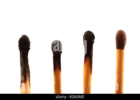 Four matches - three used and one unused - against a white background in landscape format with copy space Stock Photo