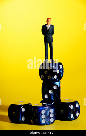 miniature figurine of a businessman standing on dice, leadership and success concept Stock Photo