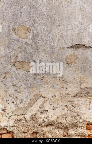 Old damaged brick wall with plaster Stock Photo