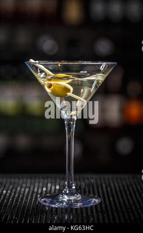 Close up of martini cocktail with green olives Stock Photo