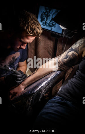 Professional tattooer create tattoo in the salon Stock Photo