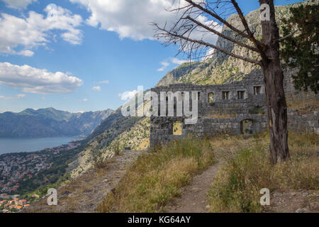 Fortress ruins along the steep climb on Kotor's Old City Walls with views out to the Fjord-like Gulf of Kotor in Montenegro Stock Photo
