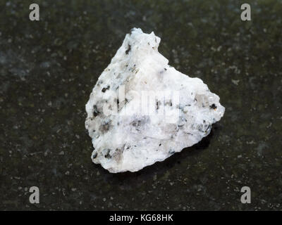 macro shooting of natural mineral rock specimen - raw Diorite stone on dark granite background Stock Photo