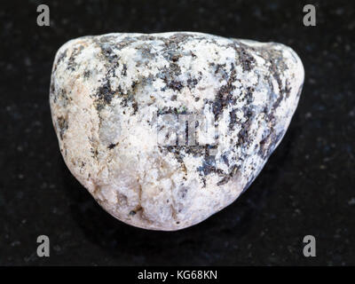 macro shooting of natural mineral rock specimen - piece of Diorite stone on dark granite background Stock Photo