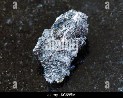 macro shooting of natural mineral rock specimen - raw hematite ore on dark granite background from Kazakhstan Stock Photo