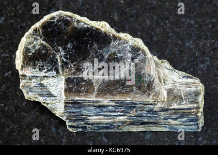 macro shooting of natural mineral rock specimen - rough muscovite mica stone on dark granite background from Pirtima mine, Karelia, Russia Stock Photo