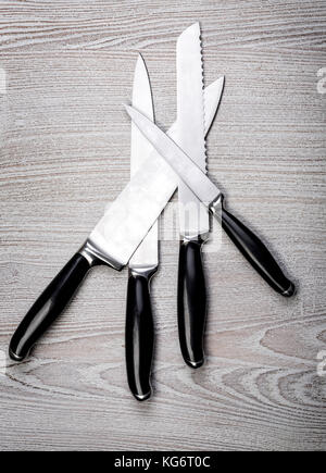 four kitchen knifes over  wooden table Stock Photo
