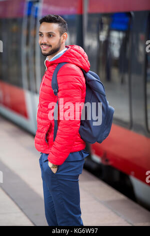 handsome man standing on platform at train station Stock Photo