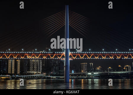 Suspension bridge against Chonging skyline at night in China