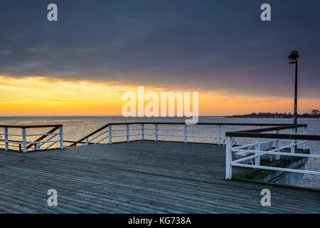 Wooden pier in Jastarnia village on Hel Peninsula at sunset time. Poland. Stock Photo