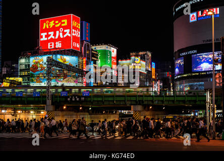 Night life in Tokyo. People cross a very busy crossroad below Shinjuku district lights Stock Photo