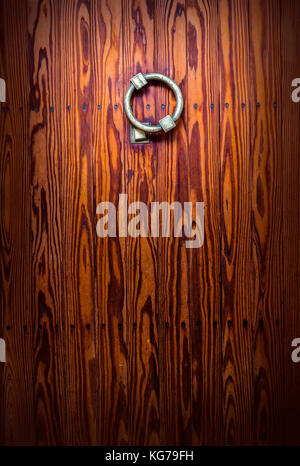 antique door knocker on wooden background Stock Photo