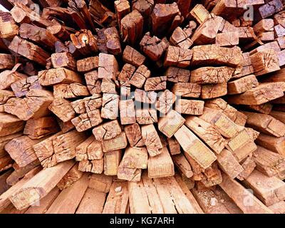 Terrible smell pile of extracted old wooden ties. Old oiled used oak railway sleepers stored after big reconstruction of old railway station. Stock Photo