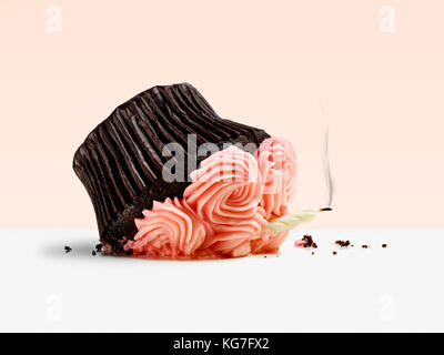 Dropped cupcake with candle and smoke on pink background Stock Photo
