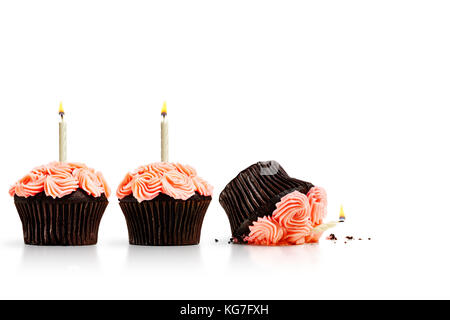 Smashed cupcake in row of cupcakes with candles isolated on white Stock Photo