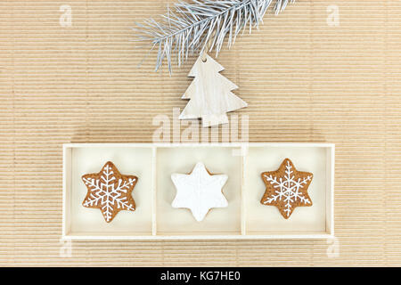 christmas gingerbreads and decorations hanging on firtree branch on brown paper background Stock Photo
